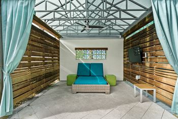 A room with a wooden wall and a blue cushion on a sofa.